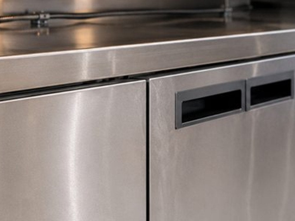 Encimera y superficies de acero inoxidable en cocina industrial de comida rápida.