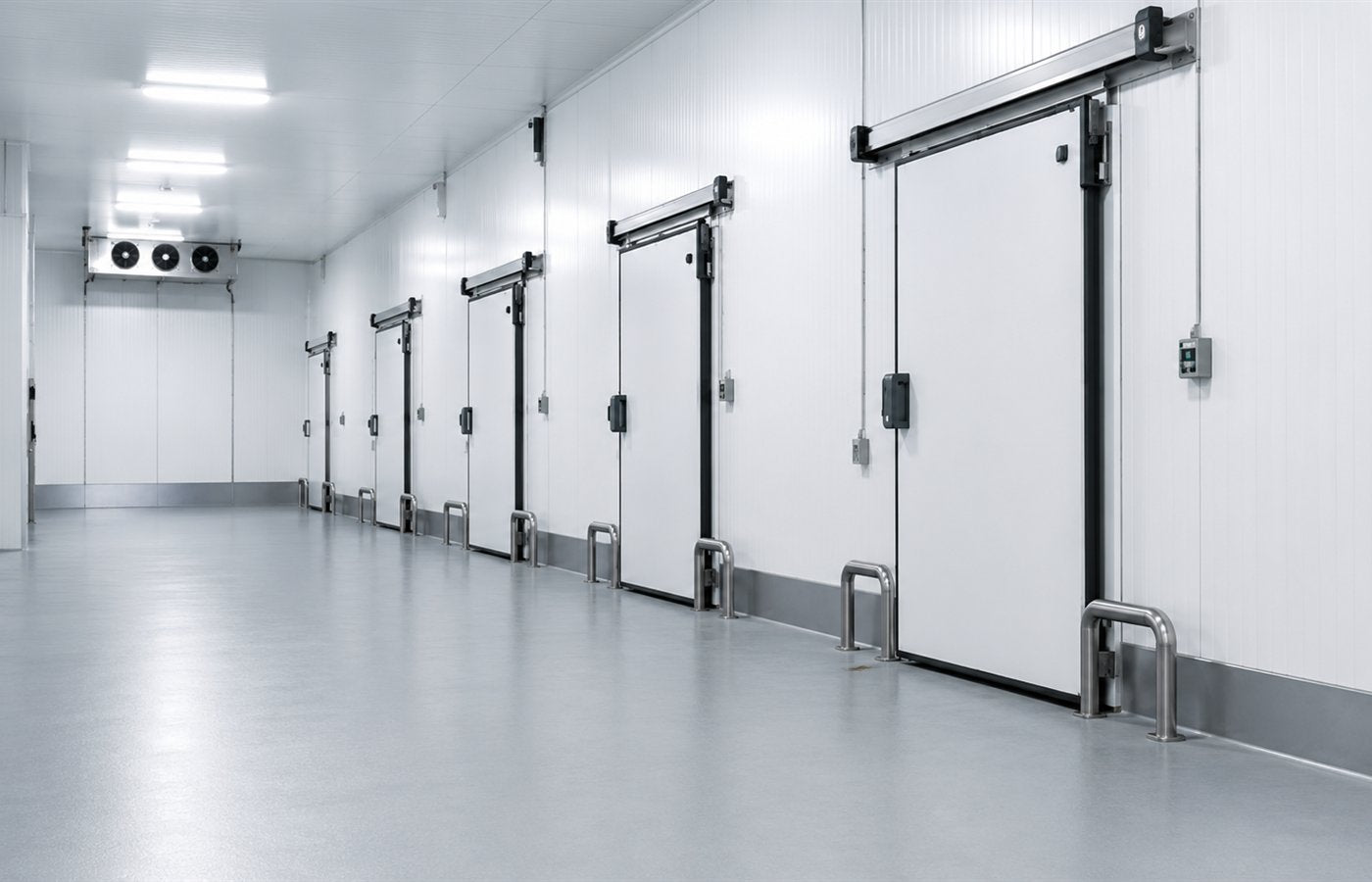 Pasillo interior de cámara frigorífica con suelo industrial y puertas isotérmicas.